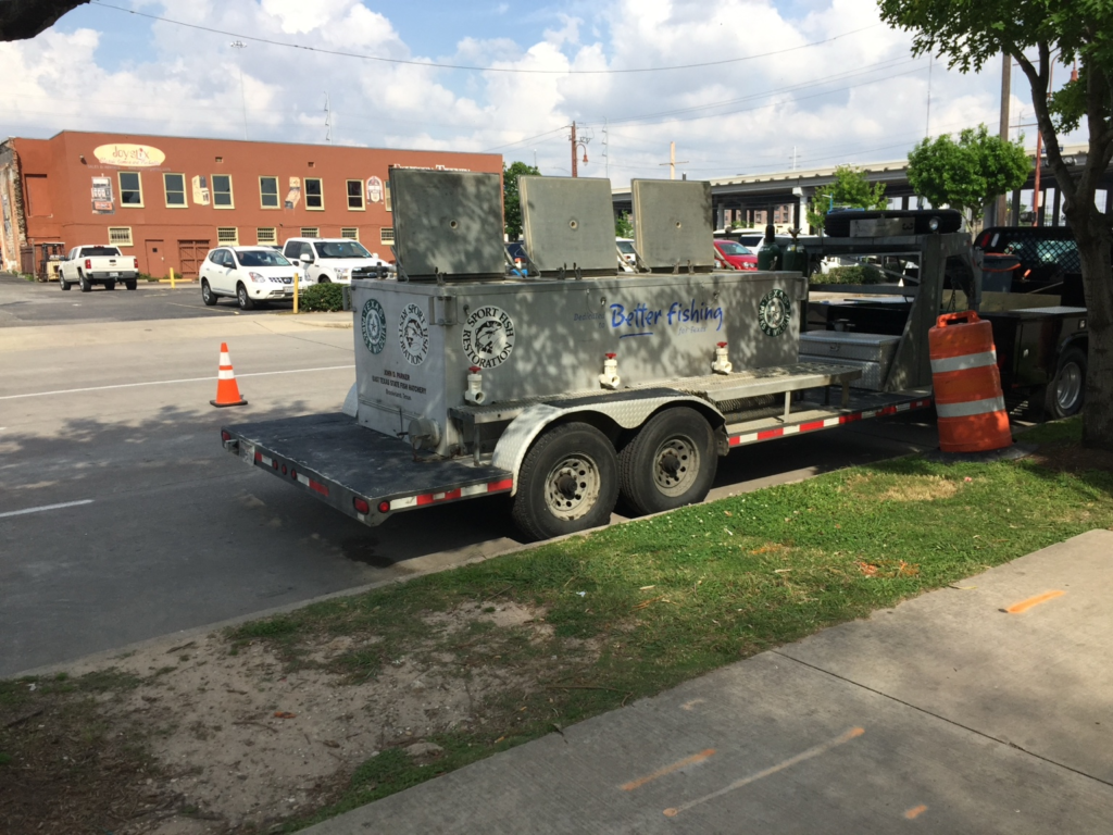 Texas Parks and Wildlife fish transport and hatchery trailer parked on a city street
