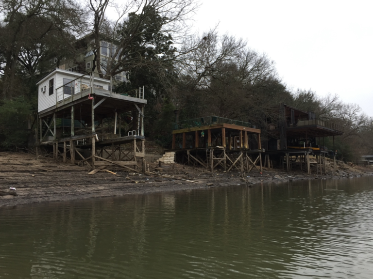 Lakeside homes and docks exposed by very low reservoir water levels